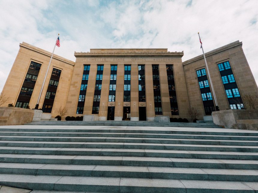Fachada do edifício do Federal Reserve dos Estados Unidos, vista de baixo, com bandeiras americanas e céu nublado