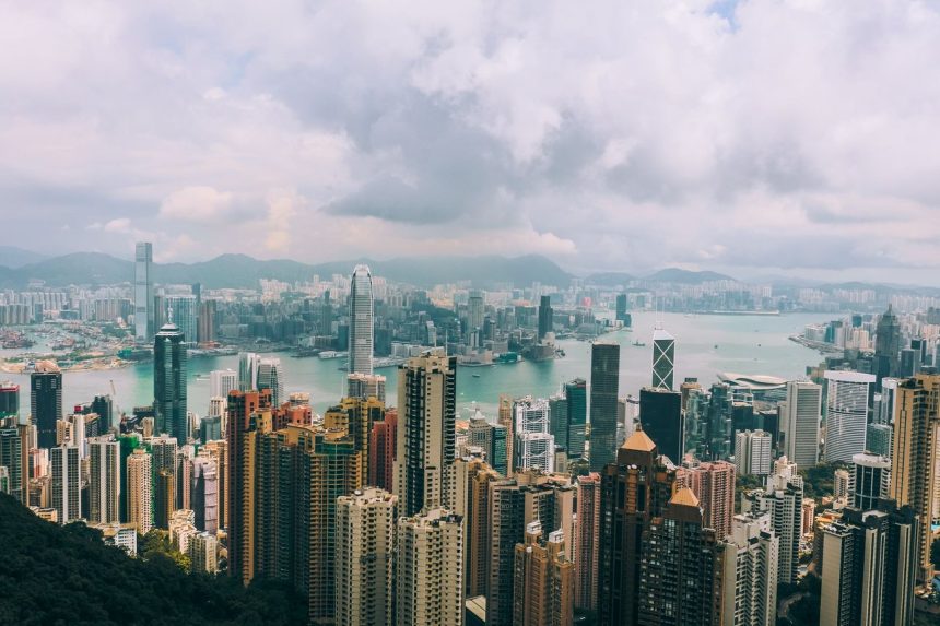 Vista panorâmica do horizonte de Hong Kong, com arranha-céus e o porto de Victoria ao fundo.