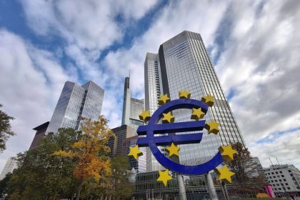 Escultura do símbolo do euro diante de arranha-céus do distrito financeiro de Frankfurt, na Alemanha.