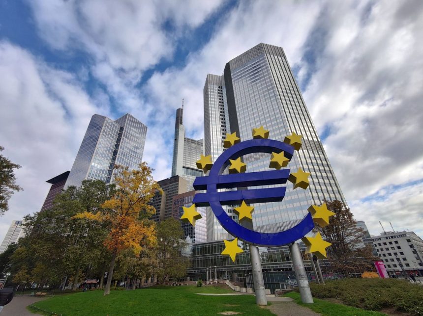 Escultura do símbolo do euro diante de arranha-céus do distrito financeiro de Frankfurt, na Alemanha.